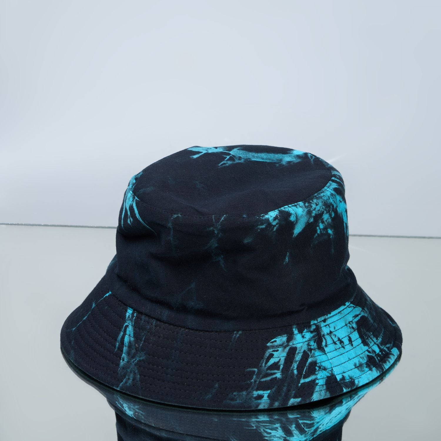 Blue and green colored, lightweight bucket hat for men, close up view.