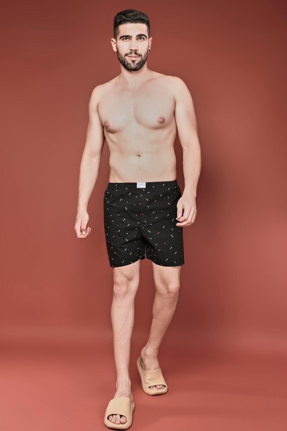 Black colored all over printed cotton boxer for men with back pockets, front view.