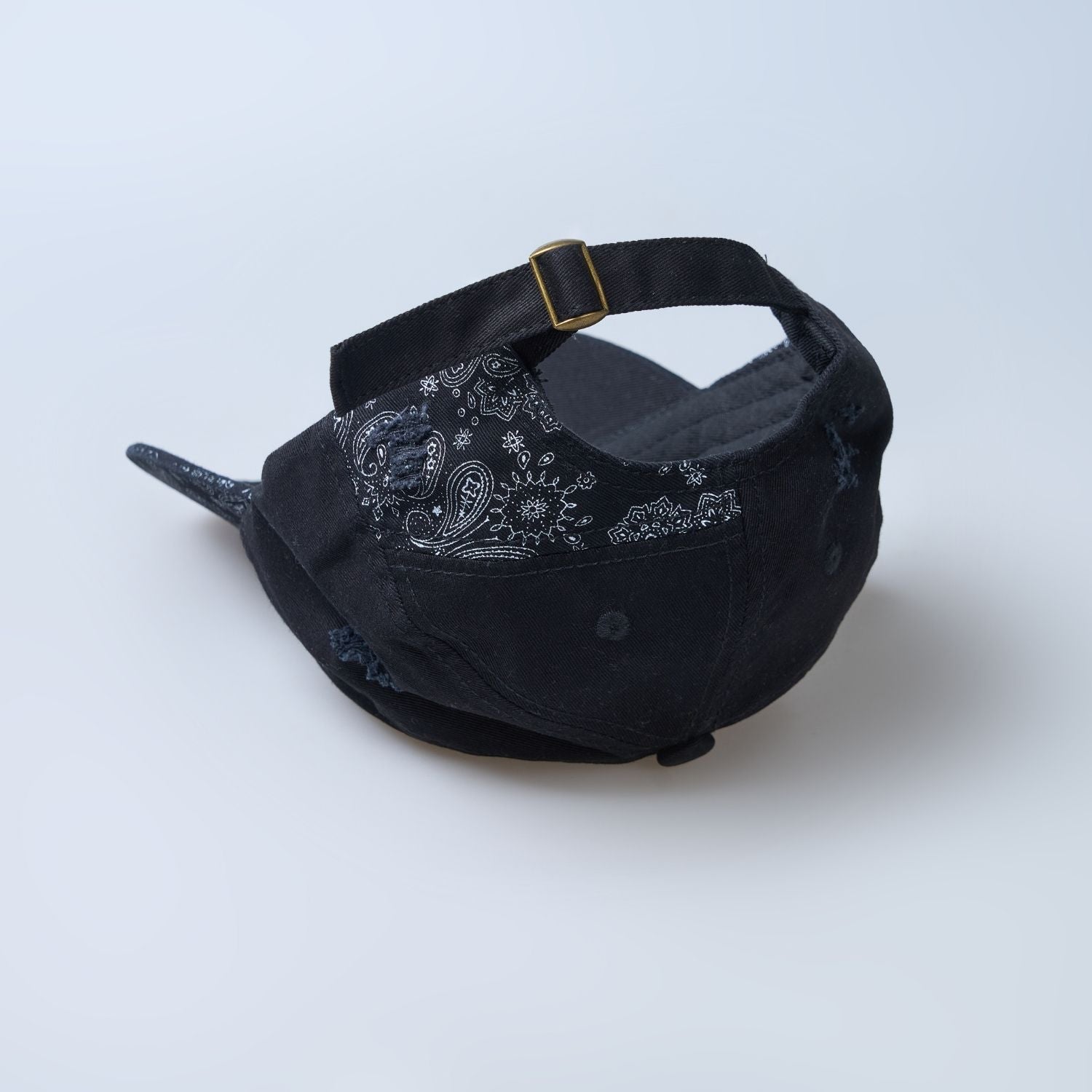Black colored design patterned cap for men, upside down.