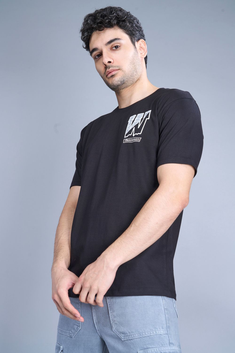 Cotton oversized T shirt for men in the solid color black with half sleeves and crew neck, side view.