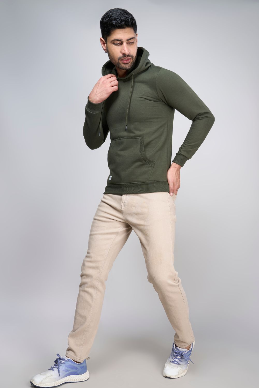 A model wearing Olive colored, hoodie for men with full sleeves and relaxed fit.