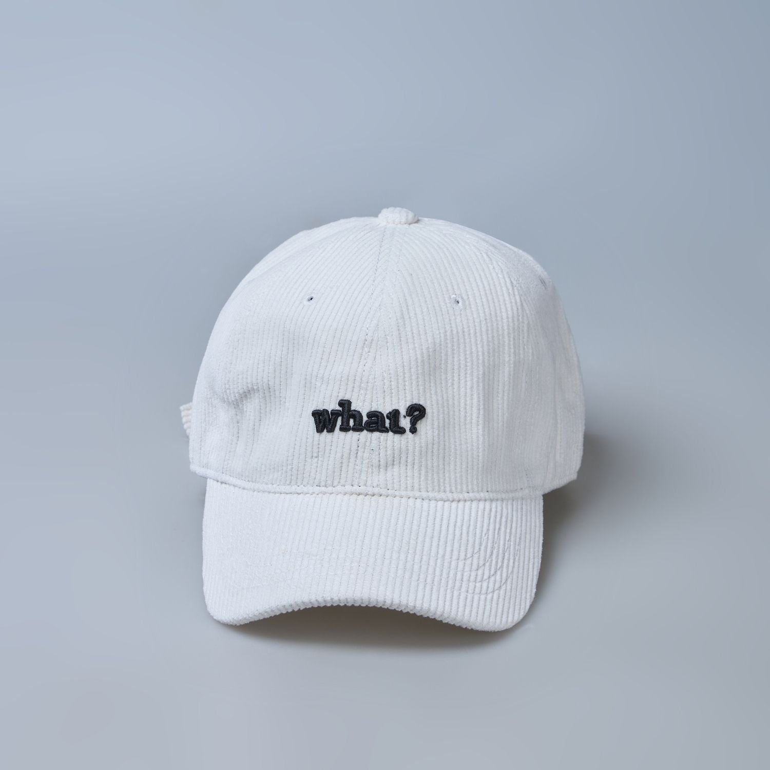 White colored cap for men with 'what' text written on it, front view.