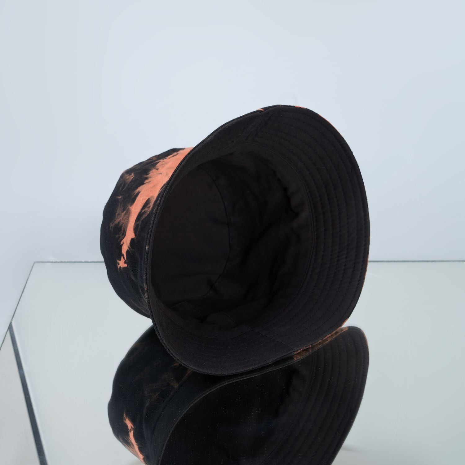 Black and orange colored, lightweight bucket hat for men, inside view.