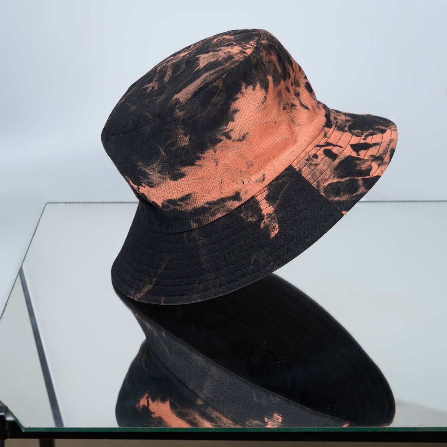 Black and orange colored, lightweight bucket hat for men, side view.
