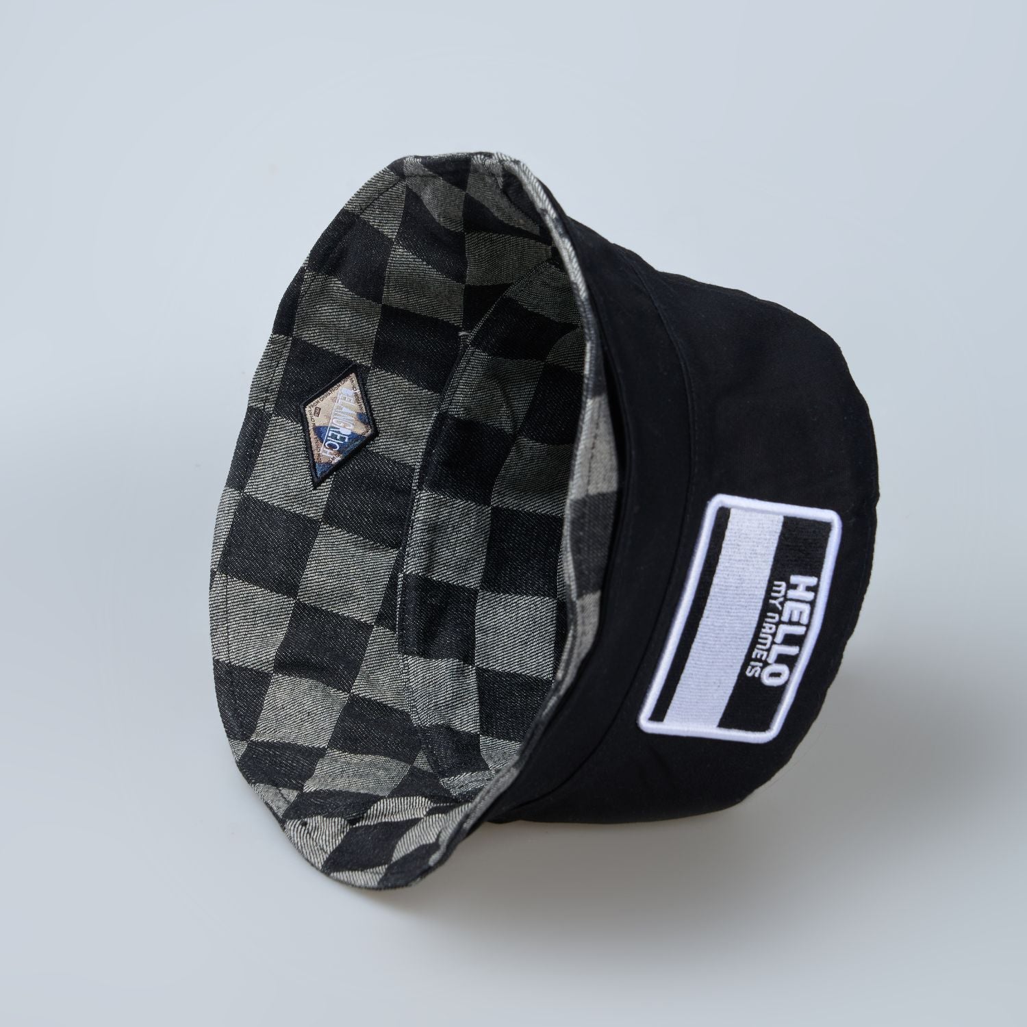 Black colored, chequered pattern, lightweight bucket hat for men, side view.