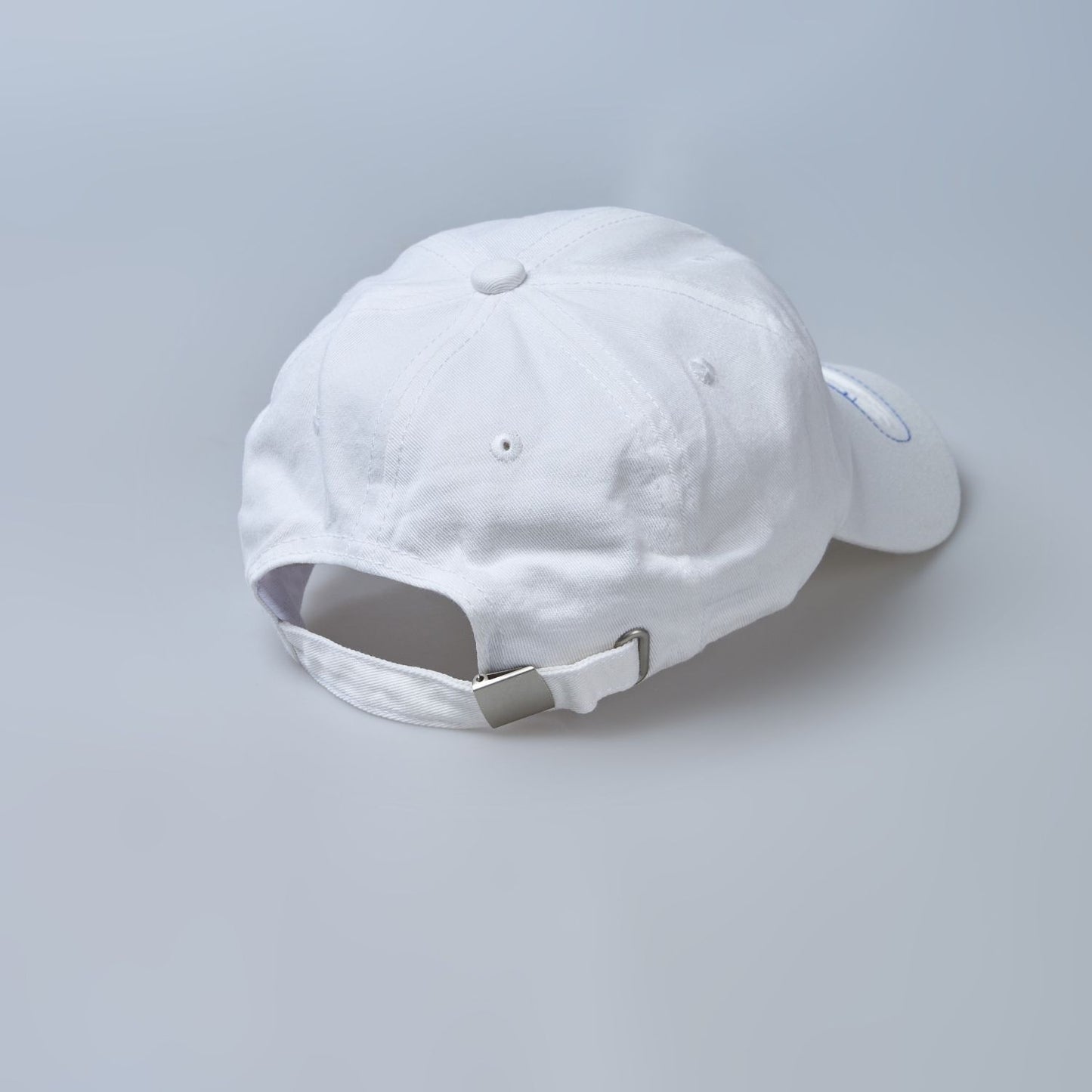 Close up of adjustable strap of white colored, wide brim cap for men.