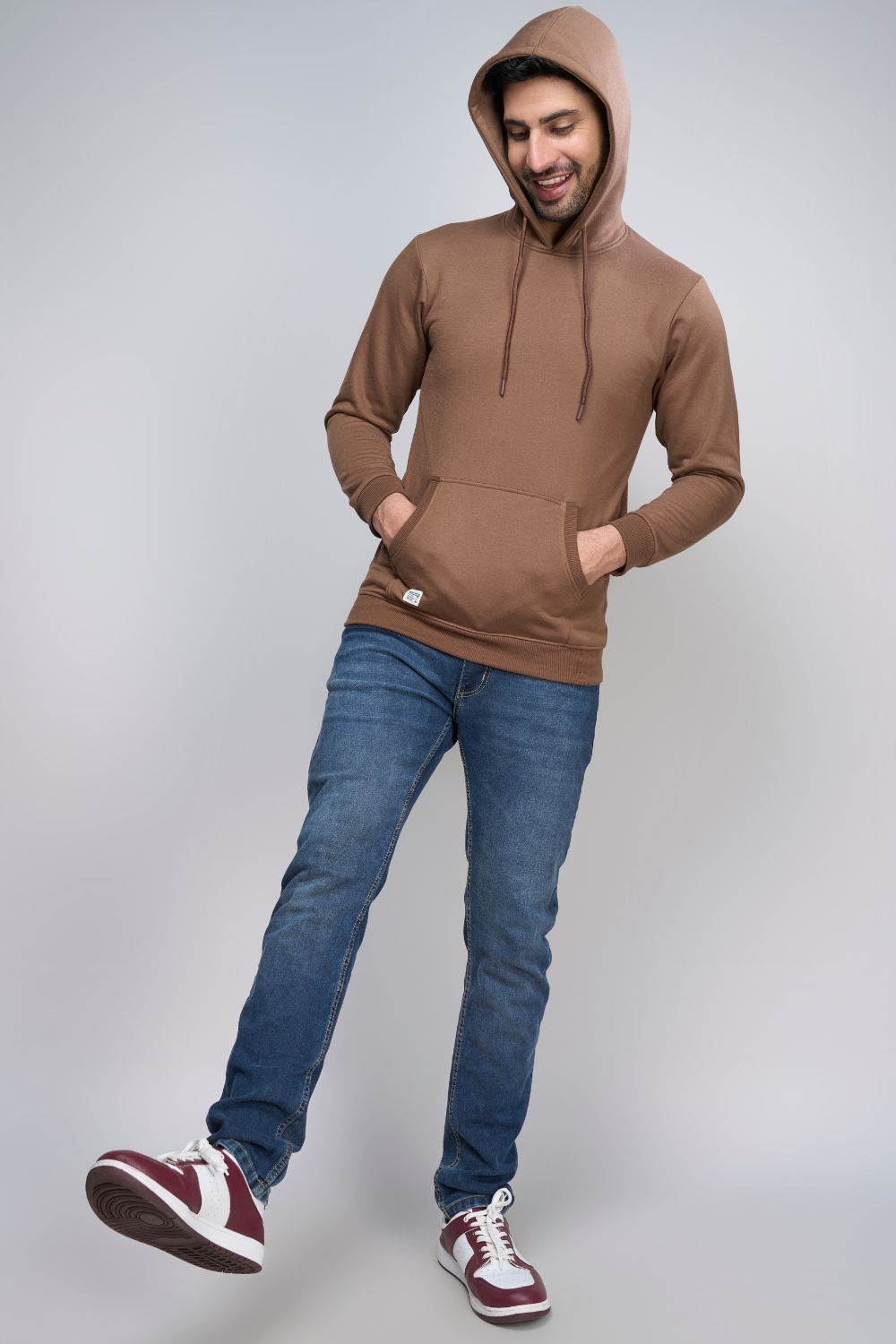A model wearing Dark Tan colored, hoodie for men with full sleeves and relaxed fit.