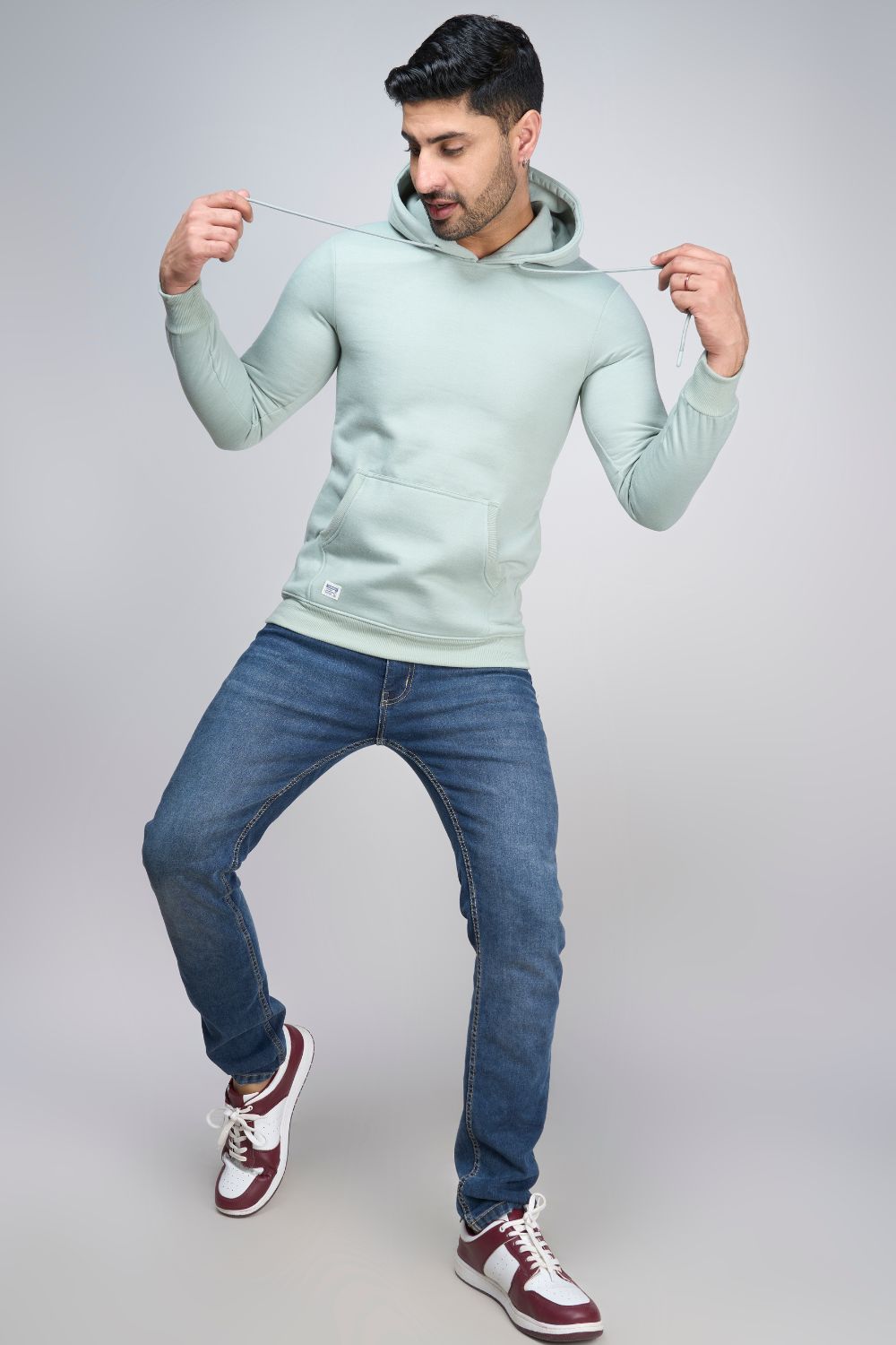 A model wearing Sea Green colored, hoodie for men with full sleeves and relaxed fit.