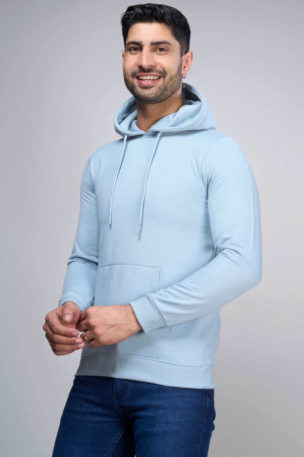 A model wearing Shenghayo Blue colored, hoodie for men with full sleeves and relaxed fit.