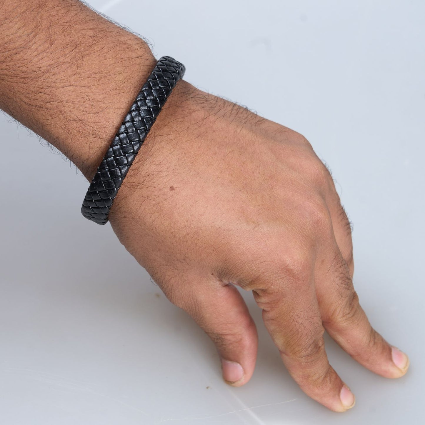 Display of Black color, snake patterned Bracelet for men, with magnetic clasp on a hand.