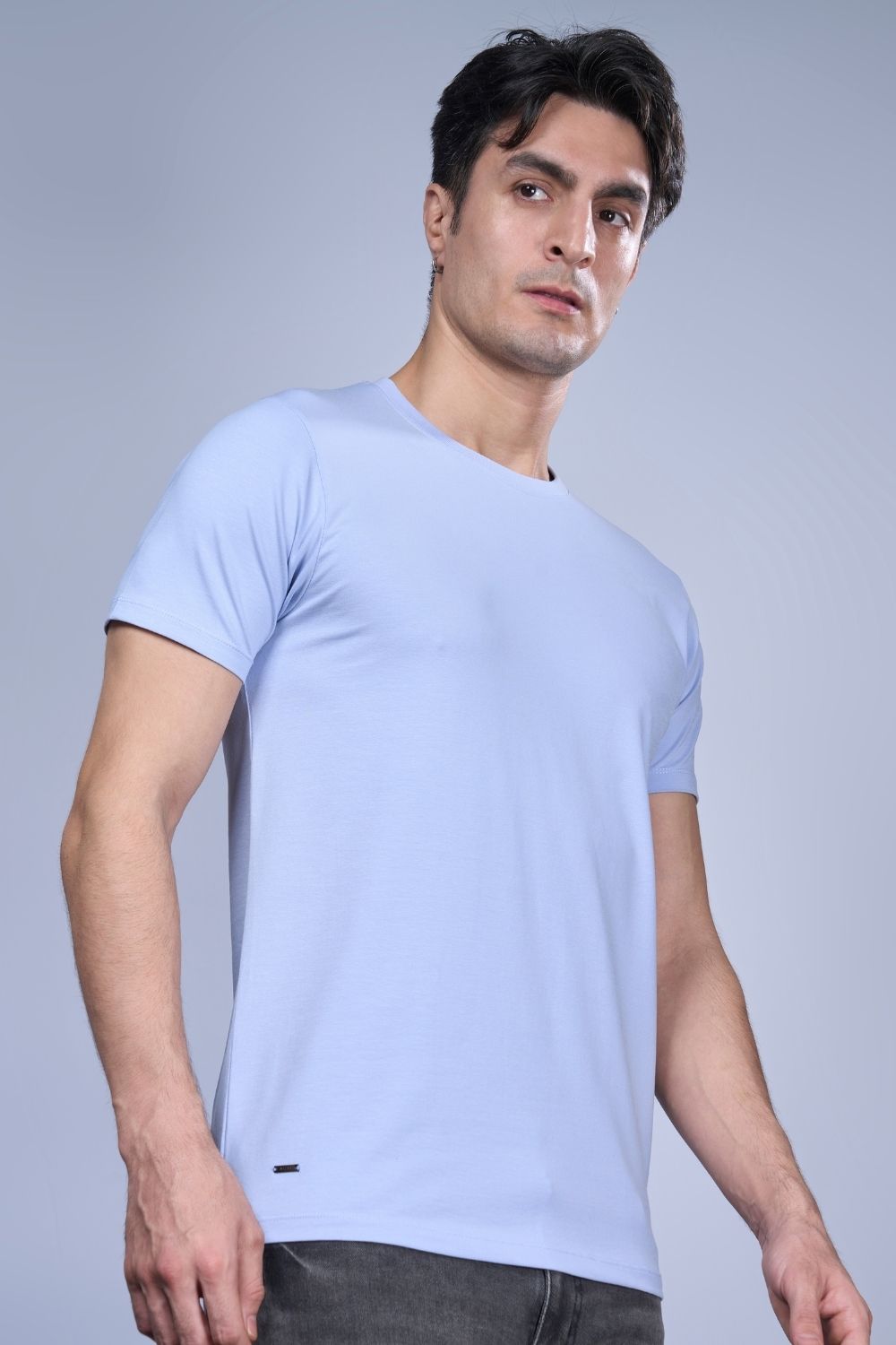 A model wearing Cotton Stretch T shirt for men in the the solid color Powder Blue with half sleeves and round neck.