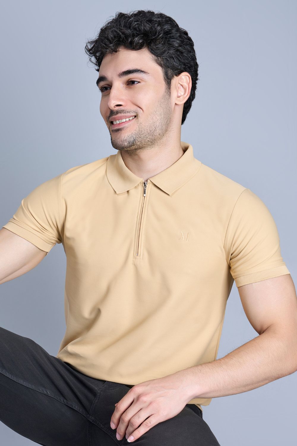 A model wearing Bisque colored, zipped Polo T-shirts for men with collar and half sleeves.