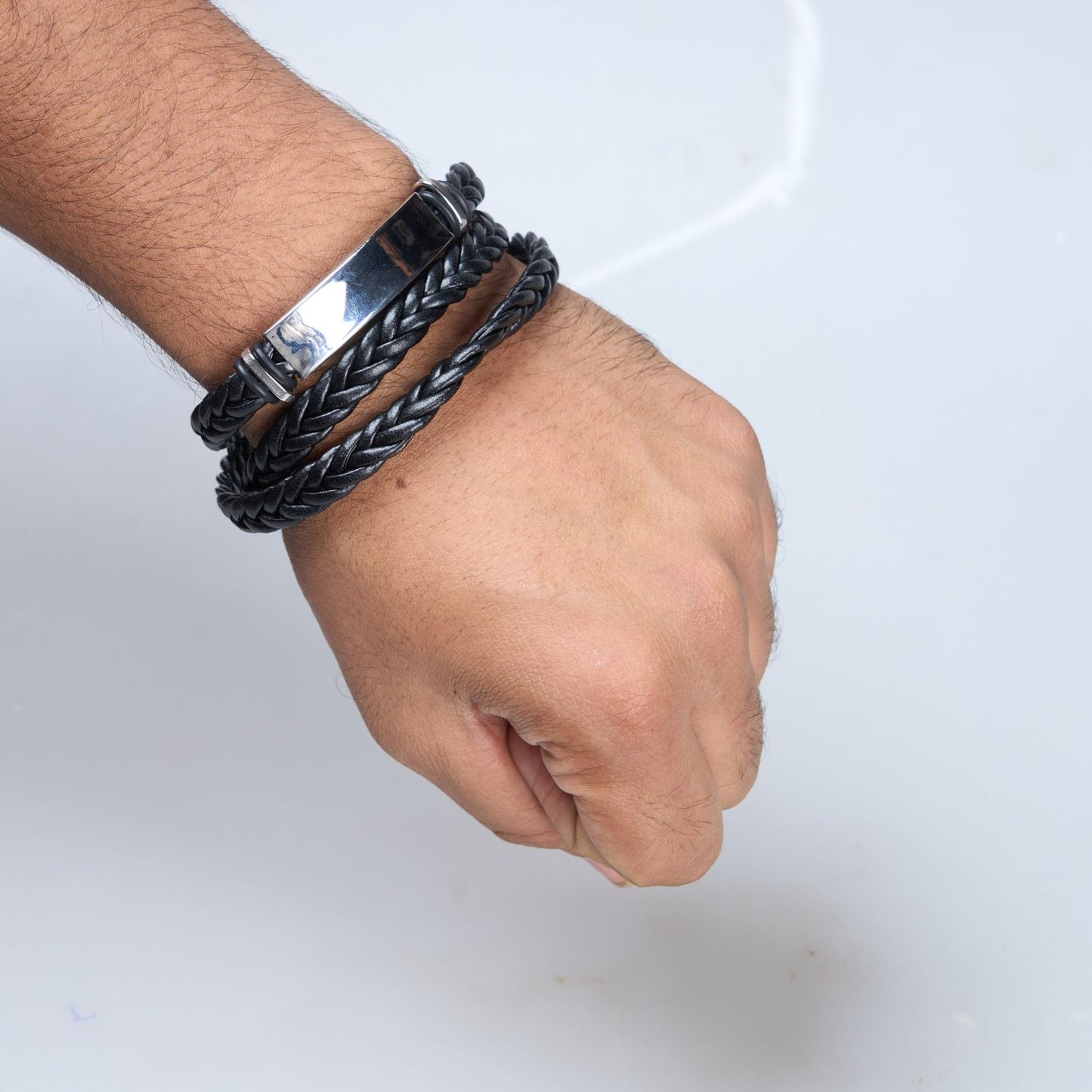 Display of Black colored long Bracelet for men, with Buckle clasp on a hand.