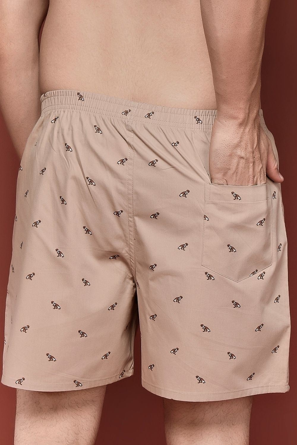 Close up of back pockets of Apricot colored all over printed cotton boxer for men.