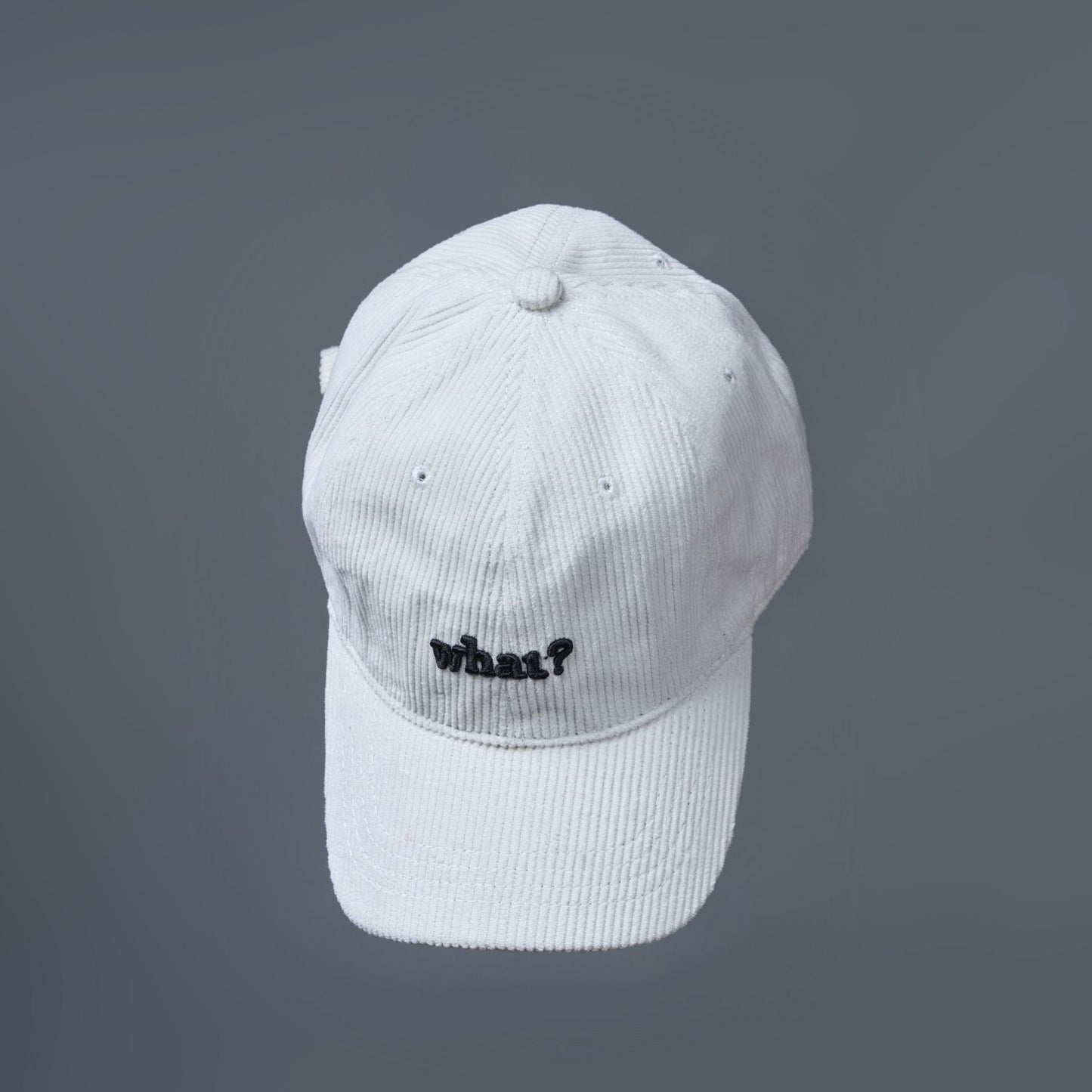 White colored cap for men with 'what' text written on it.