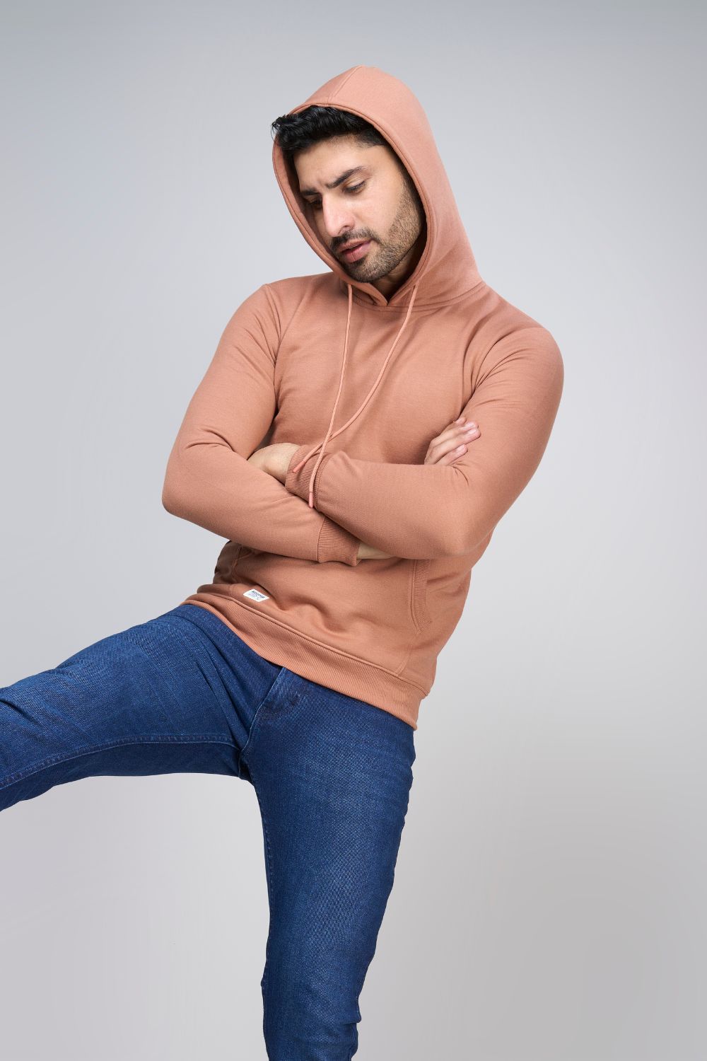 A model wearing Leather Brown colored, hoodie for men with full sleeves and relaxed fit.