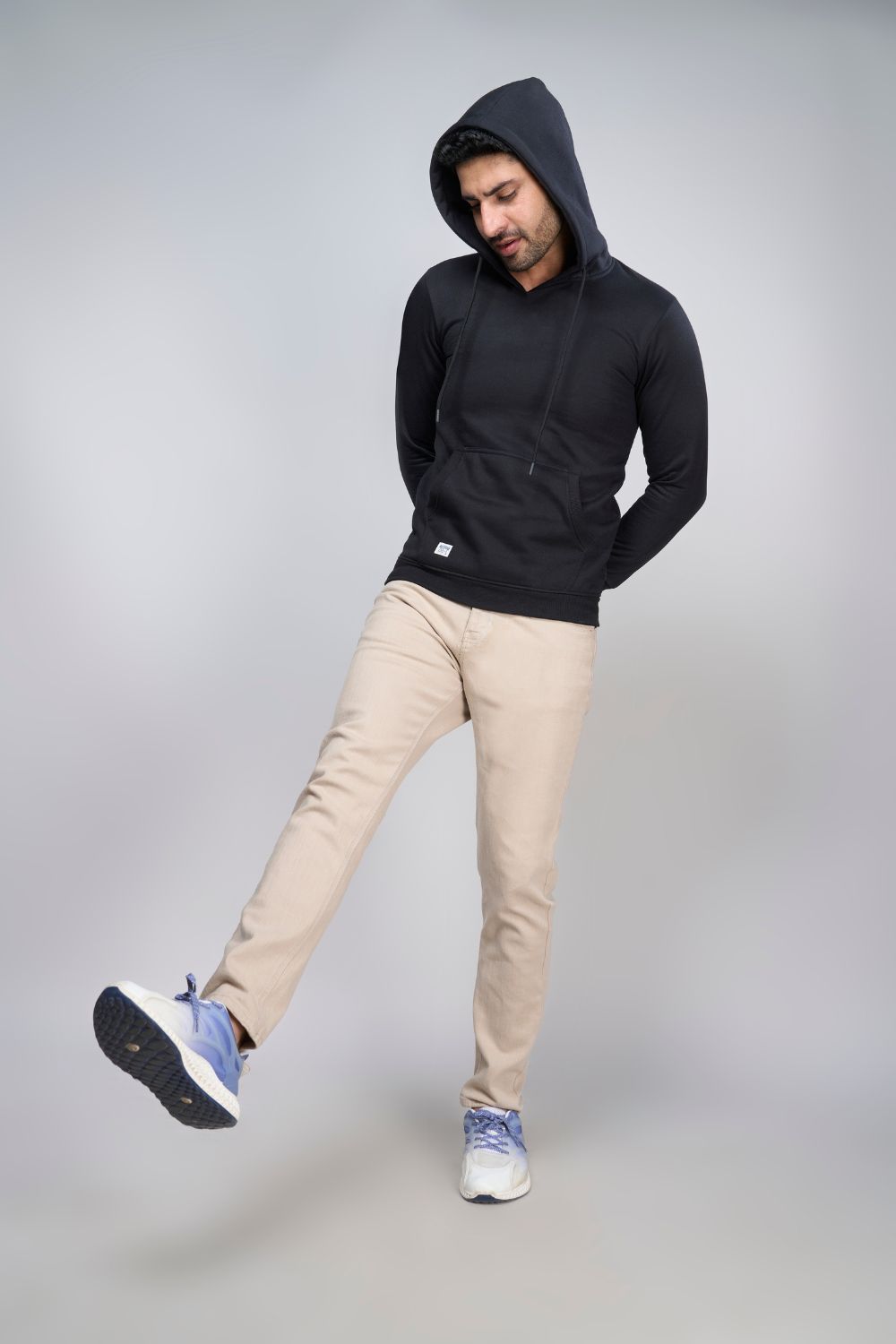 A model wearing Black colored, hoodie for men with full sleeves and relaxed fit