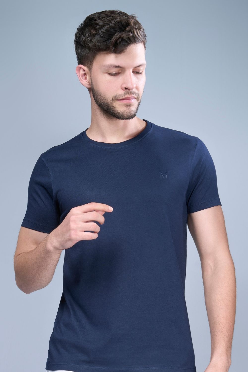A model wearing Teal Navy colored, solid t shirt for men with round neck and half sleeves